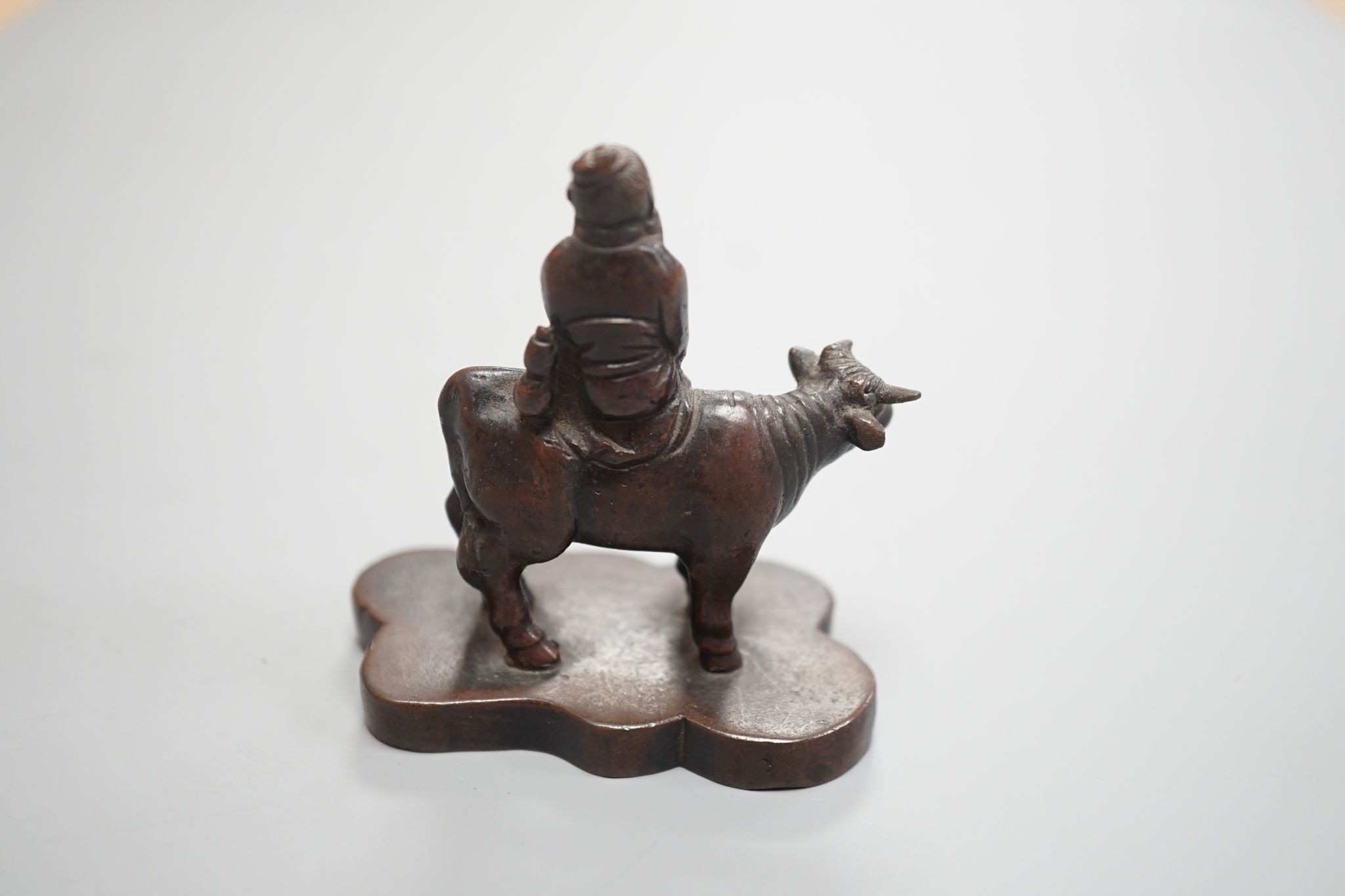 A small Chinese bronze seal of an immortal riding a bull and a Tibetan prayer case 9cm